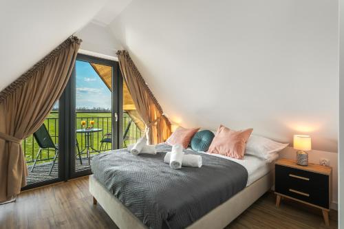 een slaapkamer met een bed en uitzicht op een balkon bij Apartament L 313 widok na góry Sun & Snow Resorts BASEN BALIA BAWIALNIA in Białka Tatrzanska
