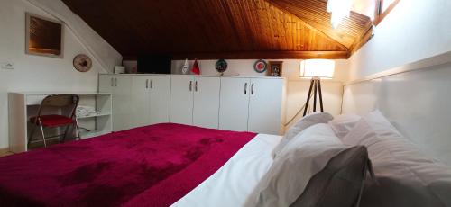 una camera da letto con un grande letto con una coperta viola di Tirana Central GuestHouse a Tirana