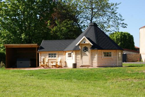 eine große Holzhütte mit schwarzem Dach in der Unterkunft Les Cabanes du Grand Nord in Pradines