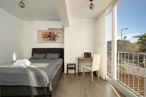 a bedroom with a bed and a desk and a balcony at Kusadasi, Villa Simsek in Kusadası