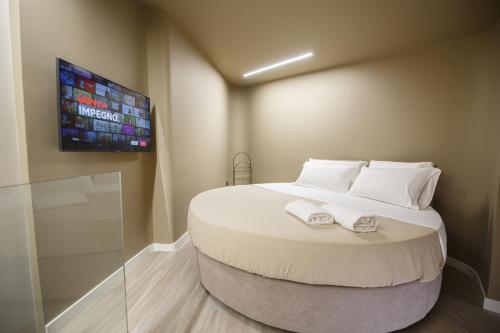 a bedroom with a large bed with two towels on it at MAZZINI PALACE in Misterbianco