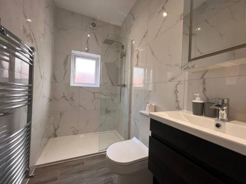 a bathroom with a toilet and a shower and a sink at Star London Finchley Road 3-Bed Escape with Garden in London