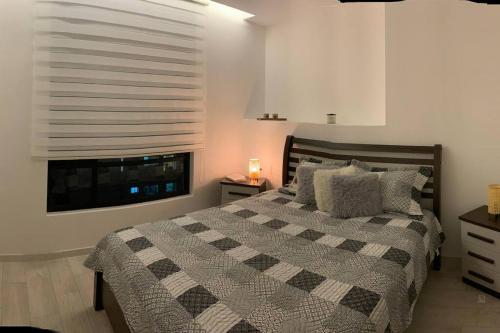 - une chambre avec un grand lit et une fenêtre dans l'établissement Espectacular departamento con vista a la Carolina, à Quito