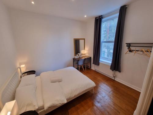 a bedroom with a white bed and a window at Horangee Pocha in London