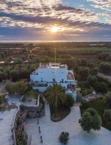 an aerial view of a white house with a sunset at Masseria Alchimia in Fasano