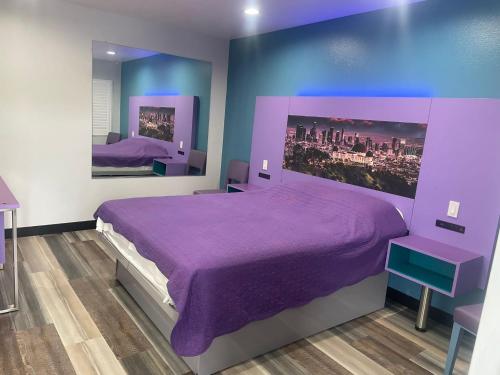 a purple bedroom with a large bed with purple sheets at Fountain Inn Motel - Alhambra, Los Angeles in Alhambra