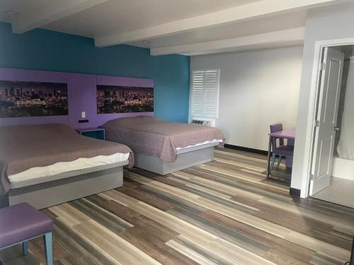 una camera da letto con due letti, un tavolo e delle sedie di Fountain Inn Motel - Alhambra, Los Angeles ad Alhambra