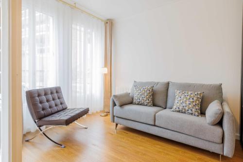 ein Wohnzimmer mit einem Sofa und einem Stuhl in der Unterkunft Beautiful apartment 4P1BR Parc Montsouris in Paris