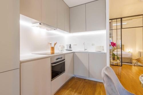 eine Küche mit weißen Schränken sowie einem Tisch und Stühlen in der Unterkunft Beautiful apartment 4P1BR Parc Montsouris in Paris
