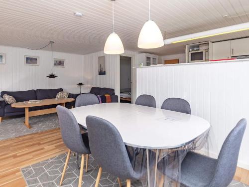 een eetkamer met een witte tafel en stoelen bij 4 person holiday home in L kken in Løkken