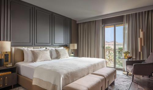 ein Schlafzimmer mit einem großen Bett und einem Fenster in der Unterkunft Anantara Plaza Nice Hotel - A Leading Hotel of the World in Nizza