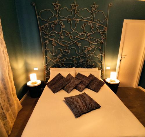 ein Bett mit zwei Kissen und zwei Kerzen. in der Unterkunft Fata Suite in Monopoli