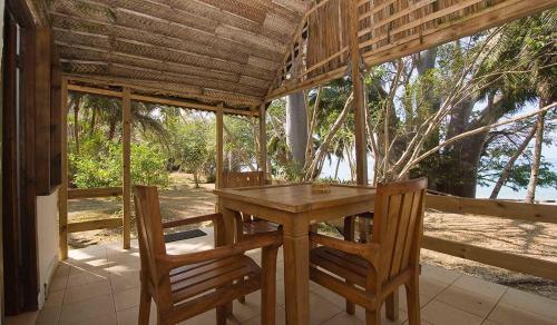 a wooden table and chairs in a pavilion at Le Jardin Maore in Kani Keli