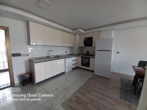 an empty kitchen with white cabinets and a table at pointrezidans in Ankara