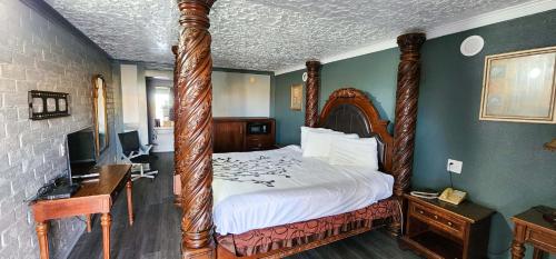 sypialnia z dużym łóżkiem z drewnianą ramą w obiekcie Stratford Inn Tyler w mieście Tyler