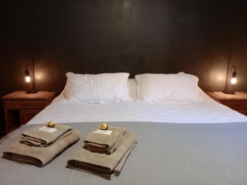 Una cama con toallas y almohadas encima. en Departamento Lorenzo I en Mendoza