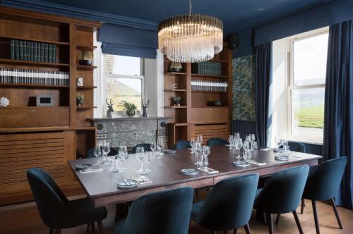 a dining room with a table and chairs and a chandelier at Aysgarth Falls Hotel & Restaurant in Aysgarth
