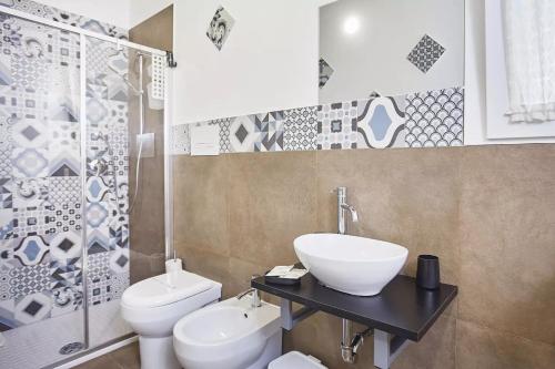 a bathroom with a sink and a toilet at Casale Sammartano Apartments in Ummari
