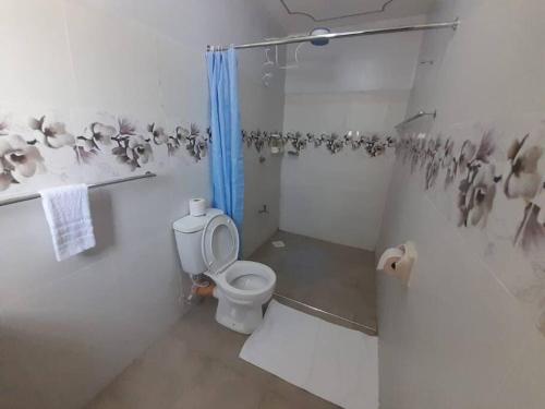 a bathroom with a toilet and a shower at Gamtoos House:Lovely 3 Bedroom House in Naivasha