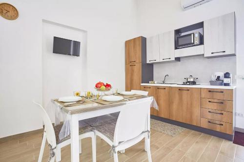 a kitchen with a white table and chairs in a room at Casale Sammartano Apartments in Ummari