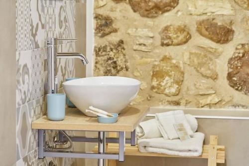a bathroom with a bowl sink on a wooden table at Casale Sammartano Apartments in Ummari