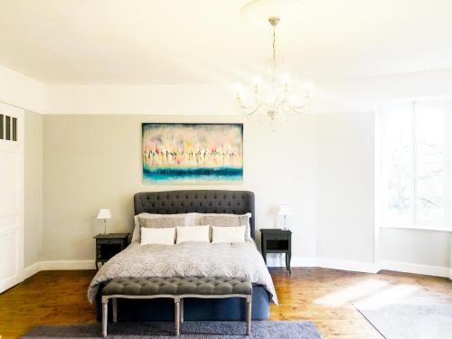 a bedroom with a bed and a painting on the wall at Chateau de la Coutere in Saint-Laurent