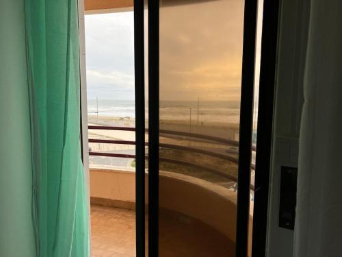 a view of the ocean from a room with a window at O mar na frente de lux Caparica in Costa da Caparica