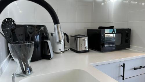 a kitchen counter with a sink and a microwave at GW945 Gugel Waves Amazing Seaview Apartments in Nahariyya