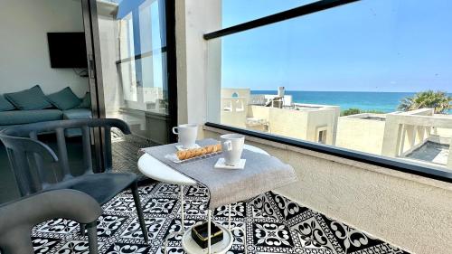 uma varanda com uma mesa e vista para o oceano em GW945 Gugel Waves Amazing Seaview Apartments em Nahariya