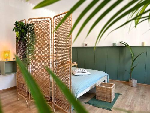 un letto in ferro in una stanza con una pianta di Cozy apartment in city center “Le petit Paris” a Lahr