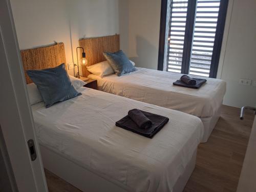 2 Betten mit Handtüchern darüber in einem Zimmer in der Unterkunft Casa del Tomate Azul in San José