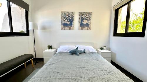 um quarto com uma cama com um gato sentado nela em GW945 Gugel Waves Amazing Seaview Apartments em Nahariya