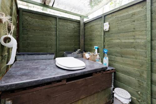 an outdoor shower with a toilet on a counter at Hobbity Bell Hobbity log burner - Hobbity stay in Canterbury