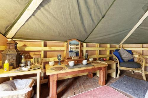 een kamer met een tafel en stoelen in een yurt bij Hobbity Bell Hobbity log burner - Hobbity stay in Canterbury