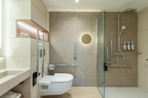 a bathroom with a toilet and a glass shower at AC Hotel by Marriott Inverness in Inverness