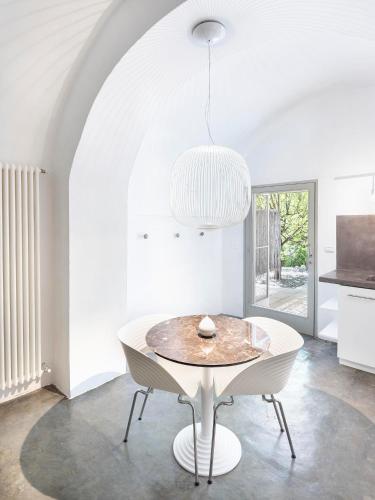 a white dining room with a table and a chandelier at Masseria Alchimia in Fasano
