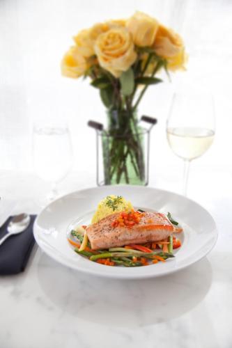 a plate of food and a vase with flowers and a glass of wine at Courtyard by Marriott Seattle Bellevue/Downtown in Bellevue