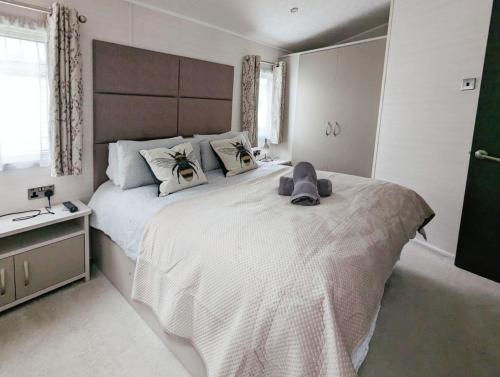 ein Schlafzimmer mit einem großen Bett mit einem Teddybär darauf in der Unterkunft Lakewood Lodge in South Cerney