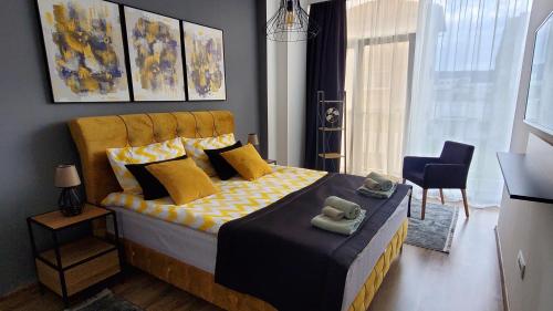 a bedroom with a large bed with yellow pillows at Apartman Gold in Bugojno