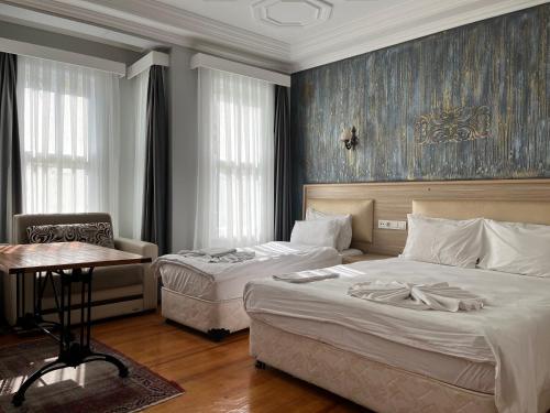 イスタンブールにあるJasmine Apart & Boutique Hotelのベッドルーム1室(ベッド2台、テーブル、椅子付)