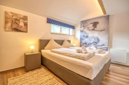 um quarto com uma cama e um quadro na parede em Apartment Melanie - by Alpen Apartments em Zell am See