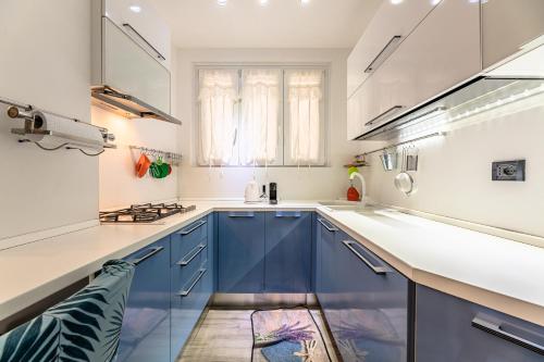 サヴォーナにあるSogno d'Estate - Appartmentoのキッチン(青いキャビネット、白いカウンタートップ付)