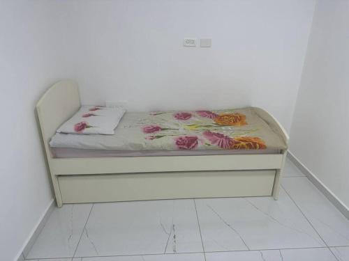 a white bed with a mattress with flowers on it at the village in Yeroẖam