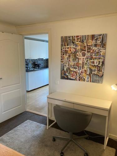 an office with a desk and a painting on the wall at Fint boende i vackra Marielund in Uppsala