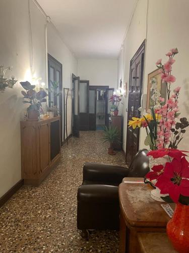 a living room with a couch and a table and flowers at Rosa apartment in Venice