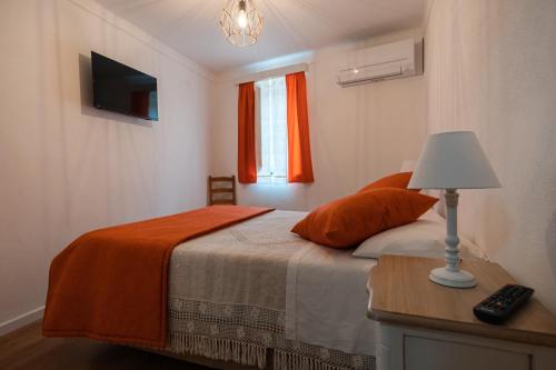 a bedroom with a bed and a lamp on a table at Casa das Ruas (Xisto Sentido®) 