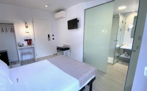 a bedroom with a white bed and a bathroom at By the Beach in Nazaré