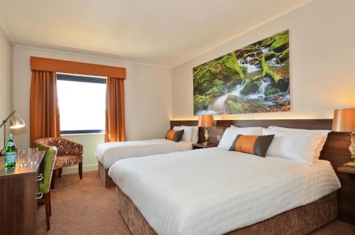 a hotel room with two beds and a desk at Nox Hotel Galway in Galway