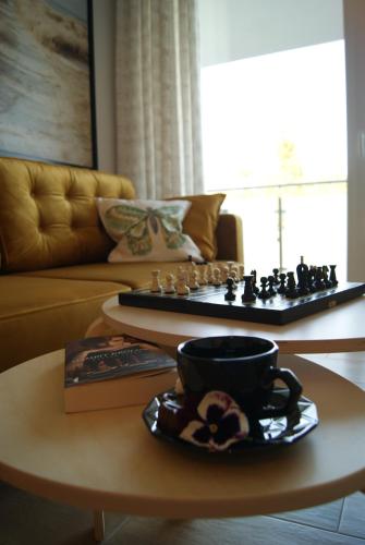 einen Couchtisch mit einem Schachbrett und einer Tasse Kaffee in der Unterkunft Apartament Garden AiR in Sztutowo
