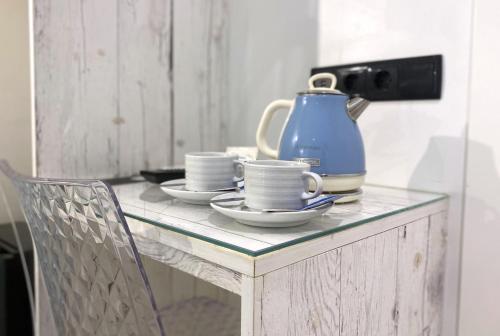 a table with a blue tea pot and saucers on it at By the Beach in Nazaré